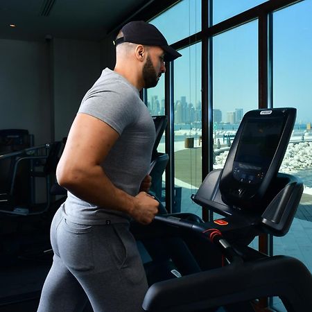Mina Hotel And Residences By The Torch Ad Dawhah Esterno foto A man exercising on a treadmill