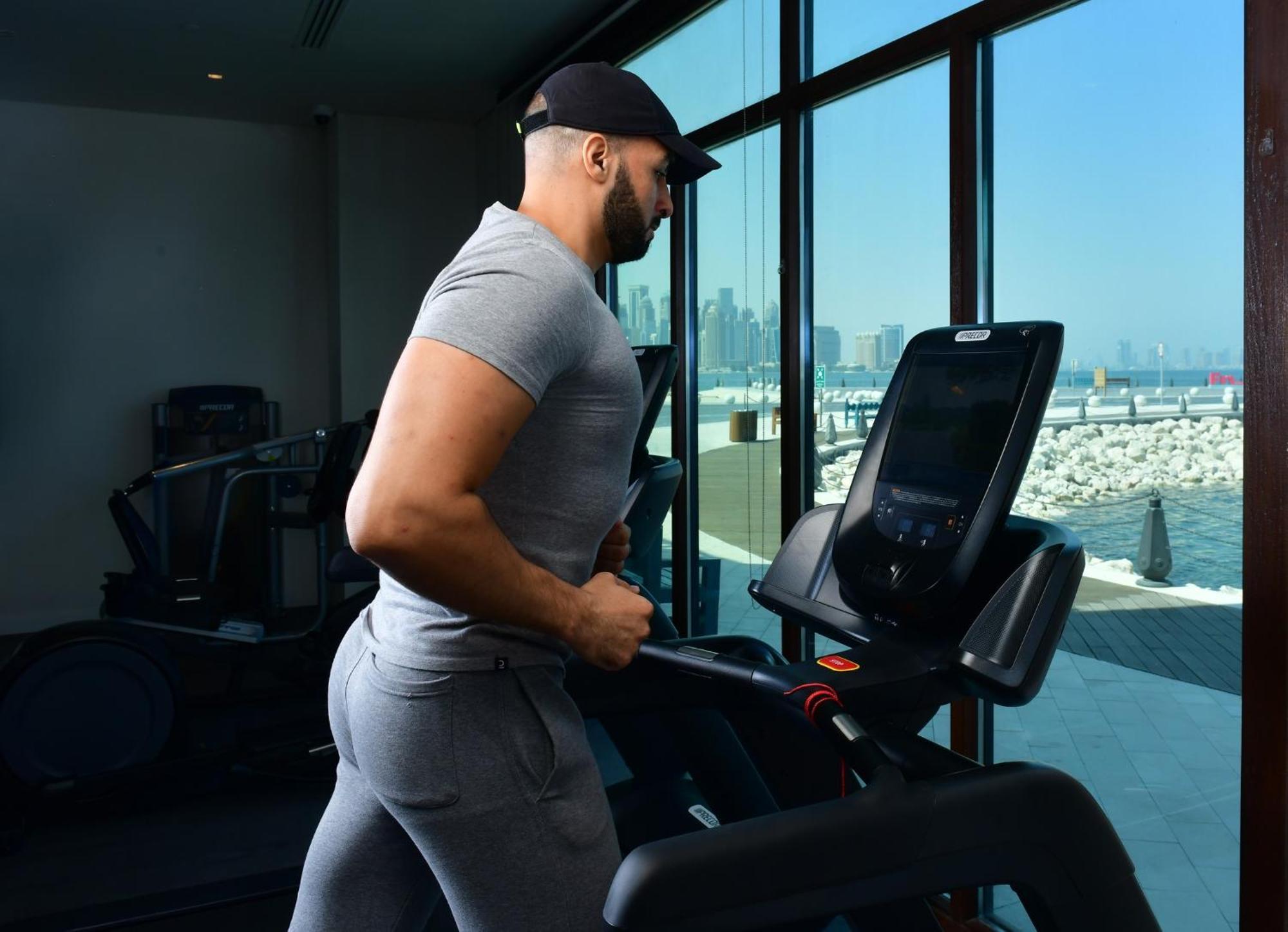 Mina Hotel And Residences By The Torch Ad Dawhah Esterno foto A man exercising on a treadmill